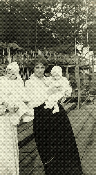 black and white photo of two women each holding a baby