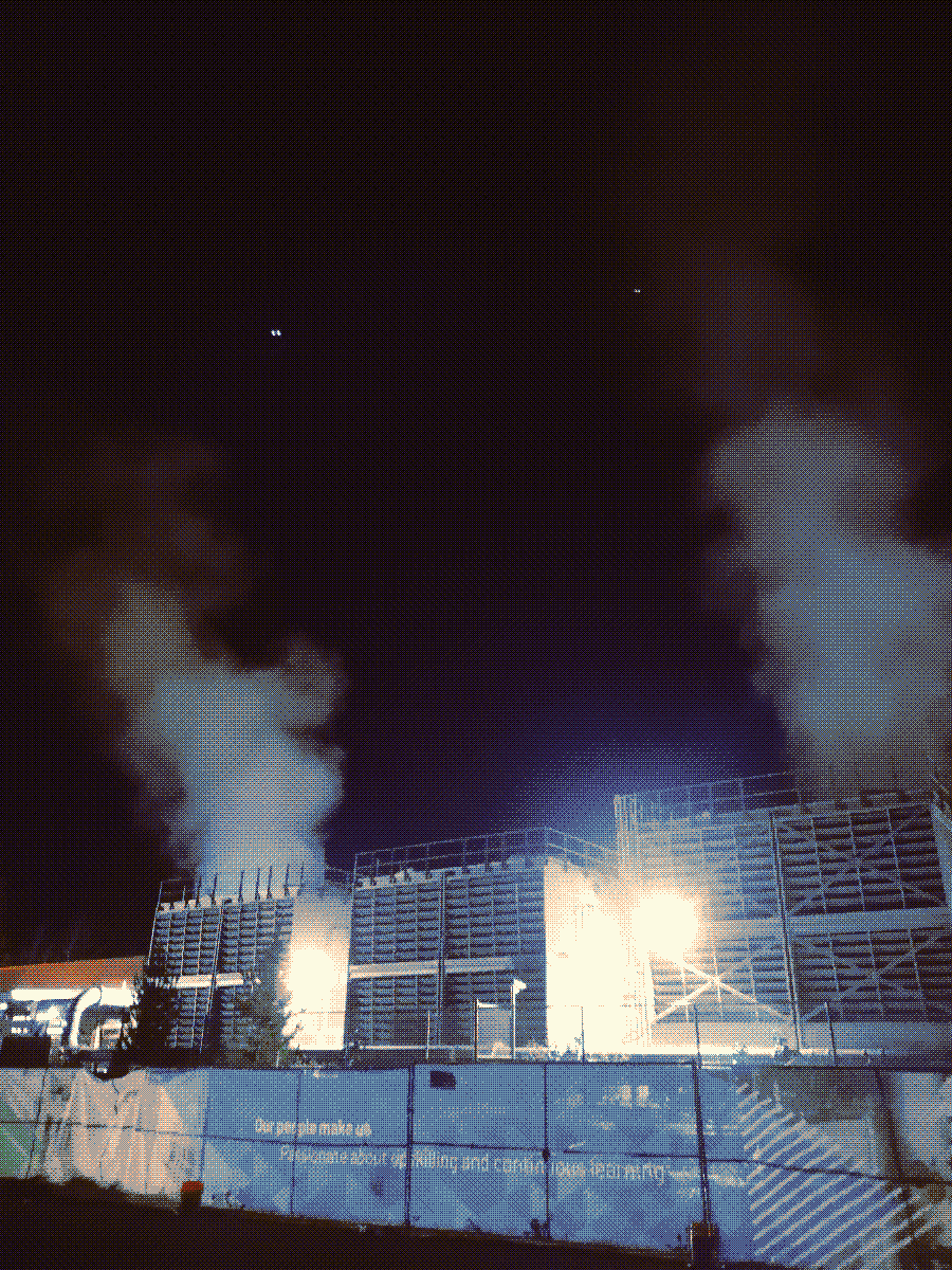 a factory emitting smog into the air in the middle of the night