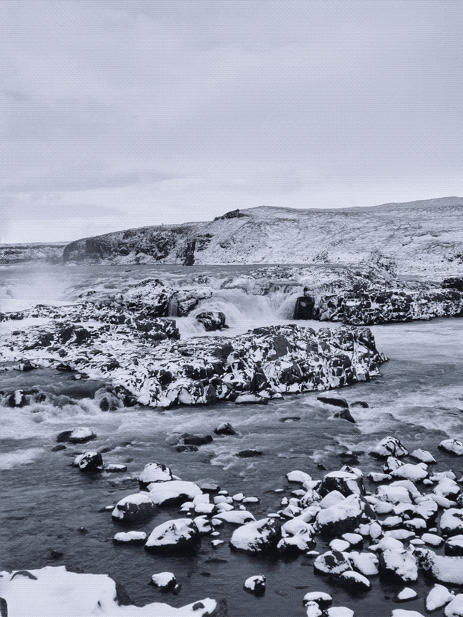 a landscape of water and rocks, with the rocks all covered in snow