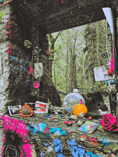 a stone window frame covered in graffiti and trinkets, with the woods visible through the frame