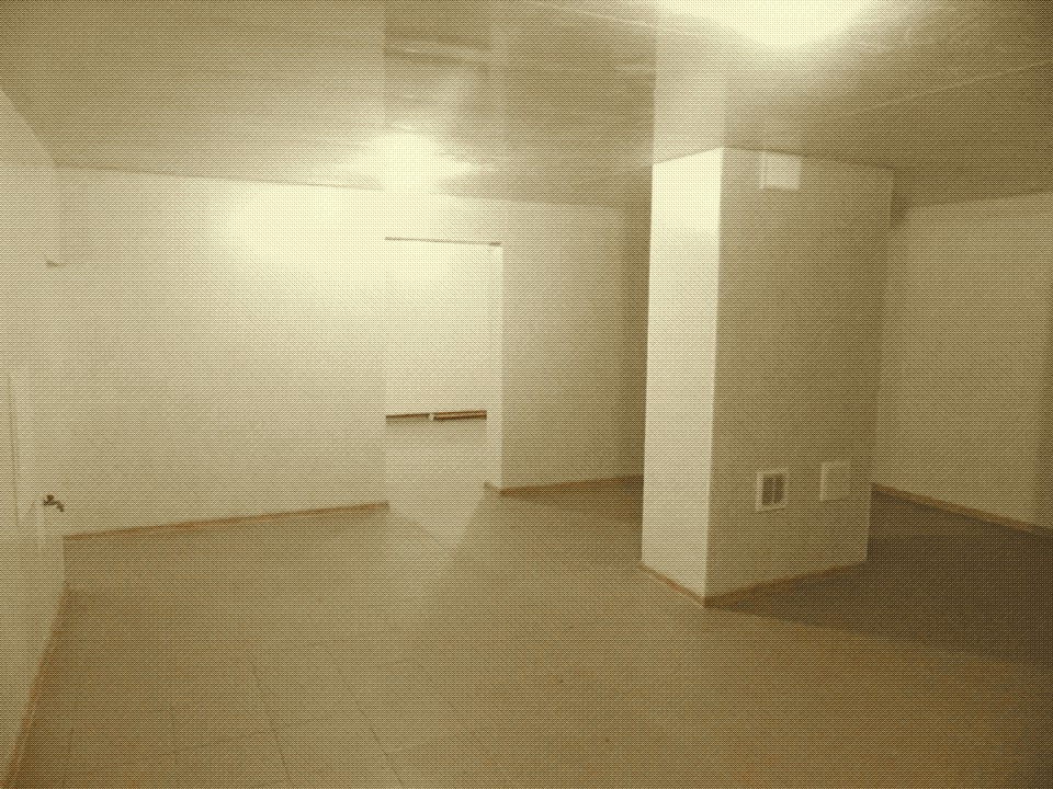 an empty room with white walls and a tiled floor, and a wide pillar near the doorway